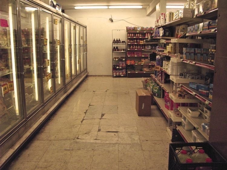 Grocery story aisle with glowing refrigerator and items on shelves