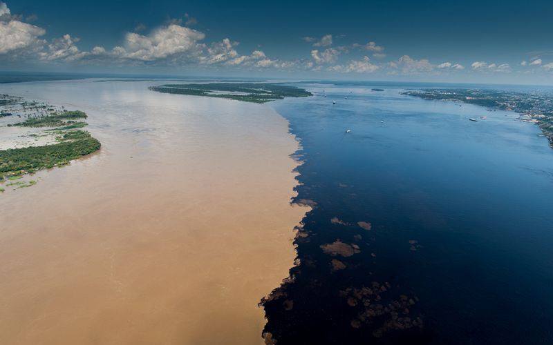 confluence between the Black river of black water and the Solimões river of muddy water, where the waters of the two rivers run side by side without mixing